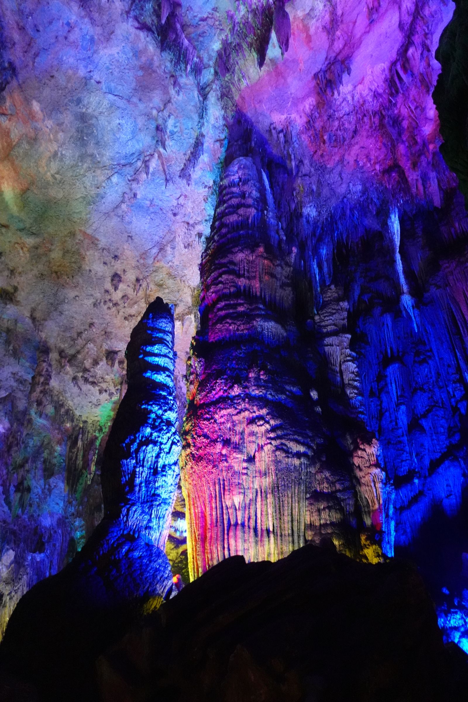 Colourful illuminated stalactites inside a limestone cave
