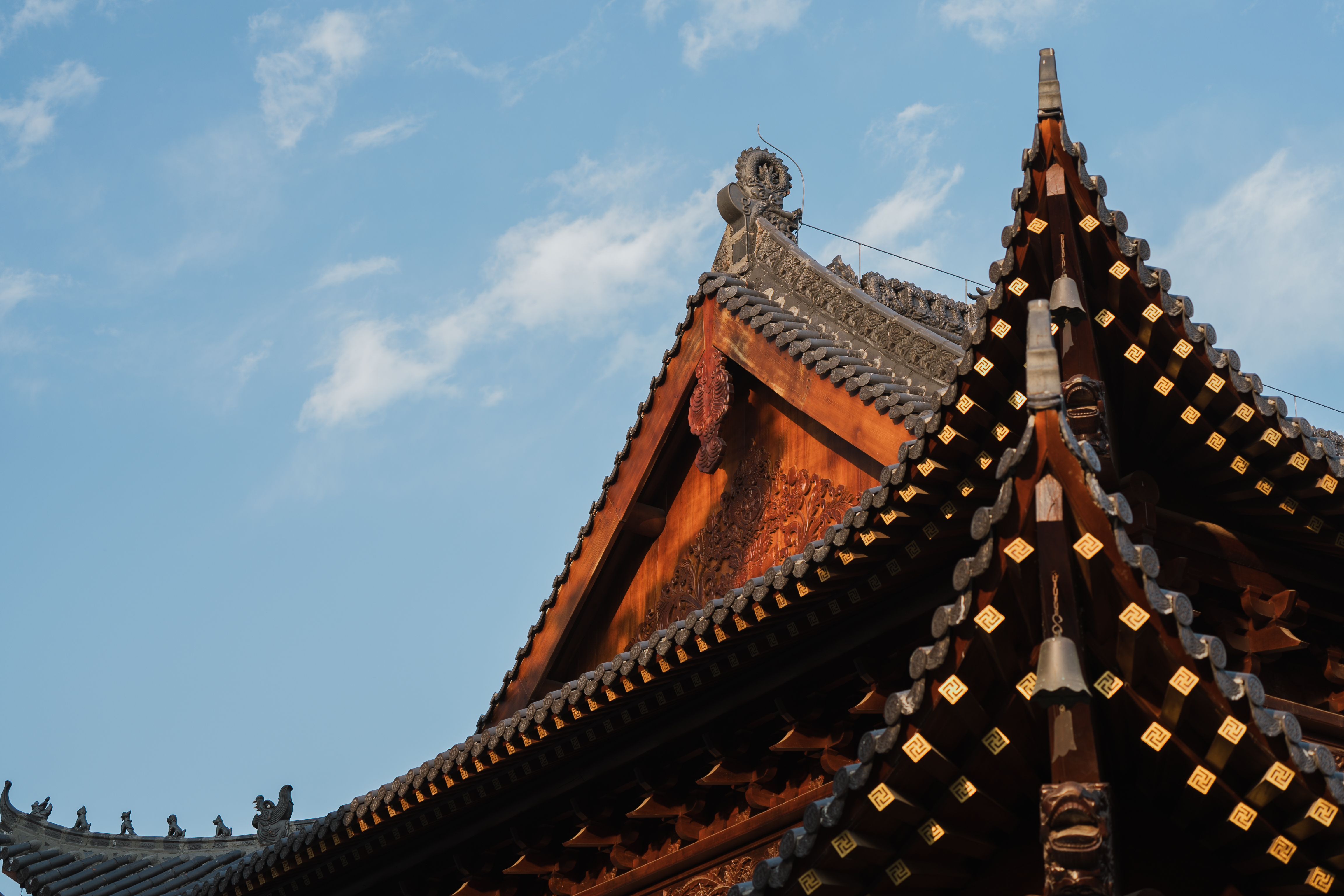 An elegant curved Chinese temple roof against a blue sky