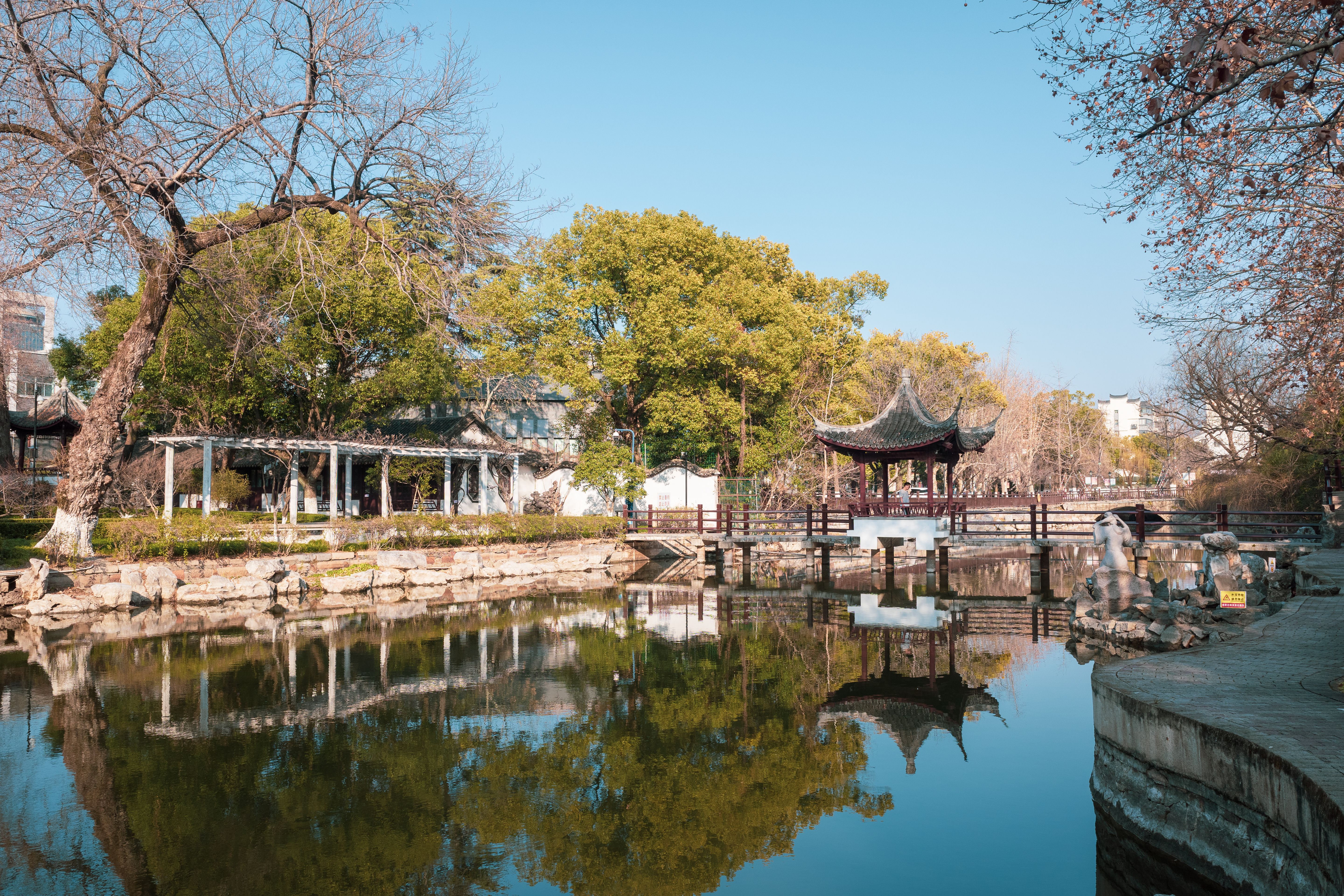 A calm pond with a Chinese pavilion in a Tianjin park