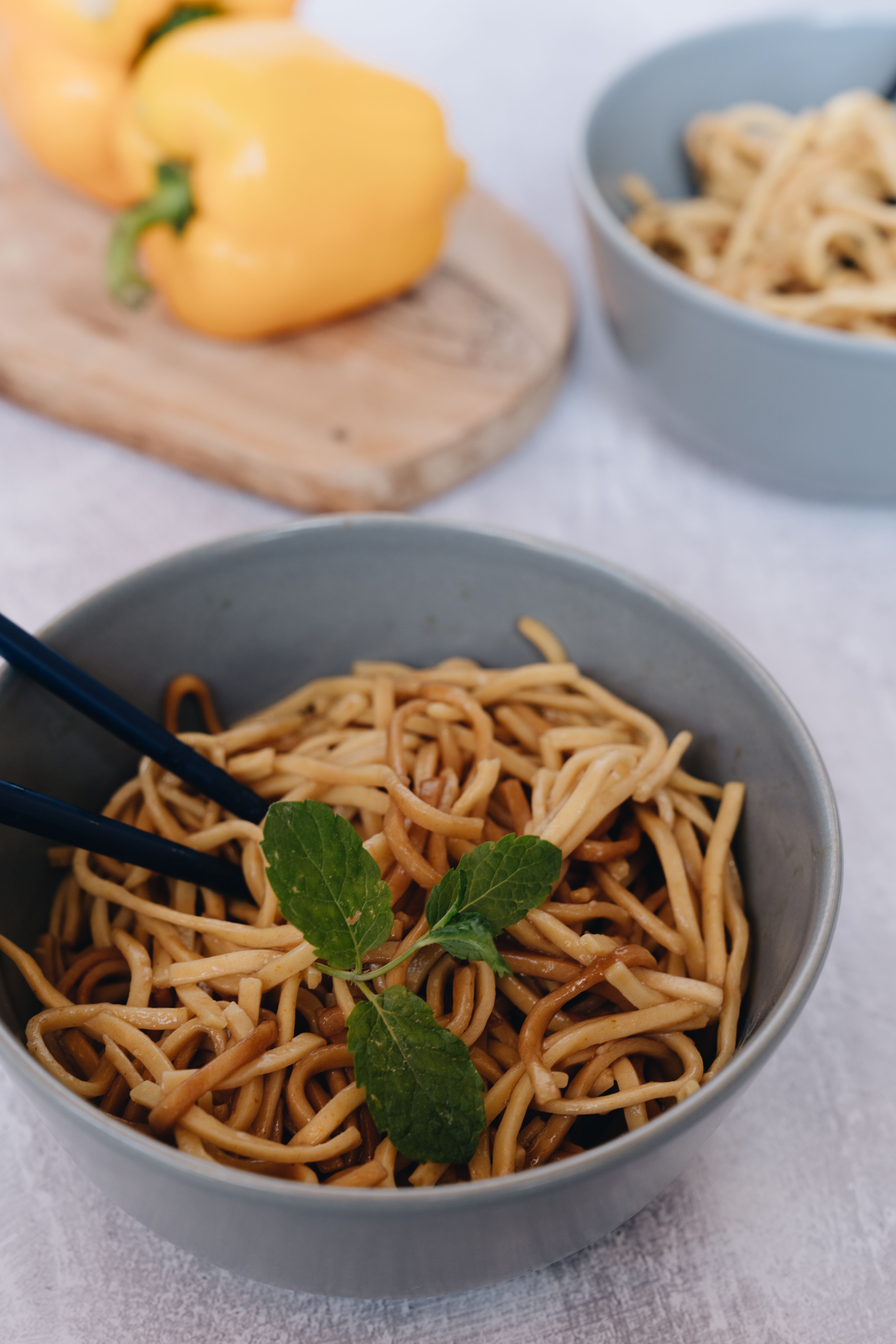 A bowl of noodles with chopsticks