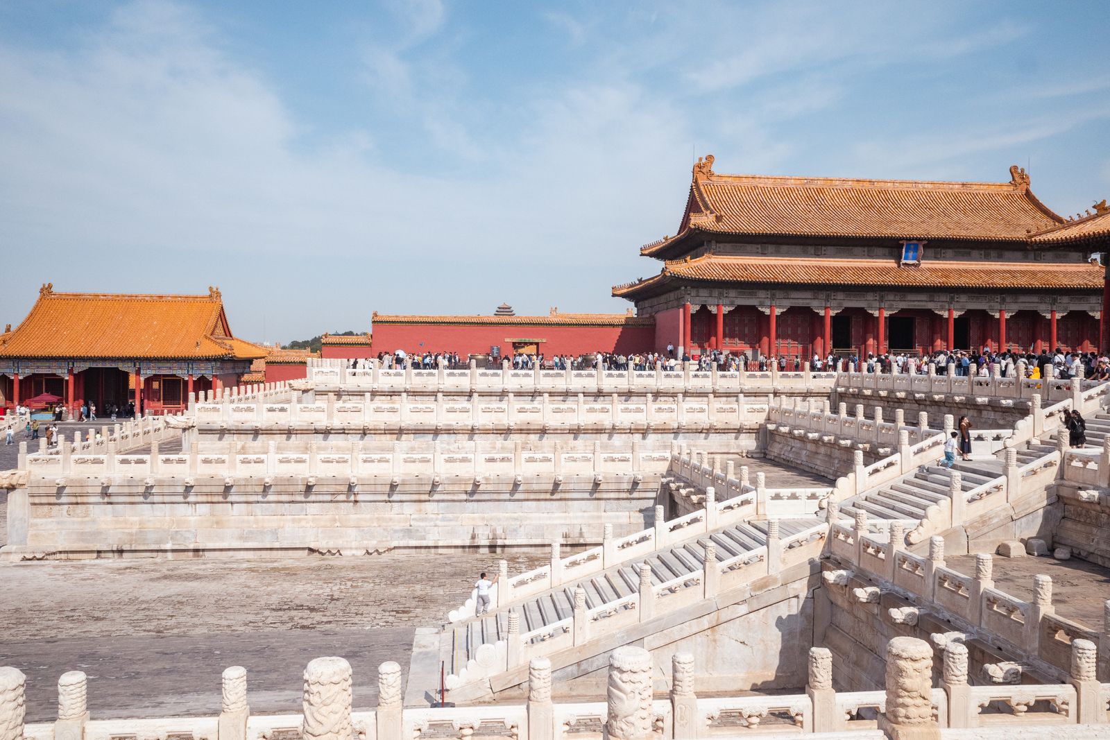 The Hall of Supreme Harmony in the Forbidden City, seen across the white marble terraces, with visitors on the staircases