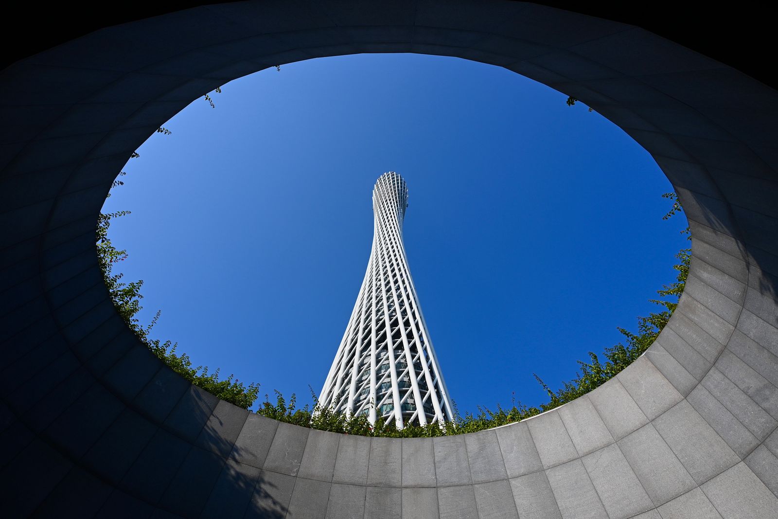 Canton Tower viewed through a circular architectural opening against a clear blue sky, Guangzhou