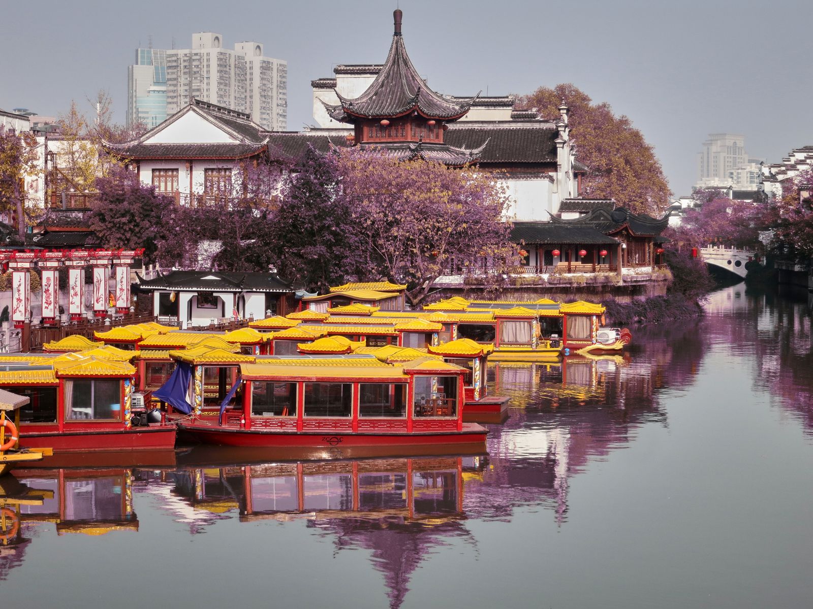Colorful traditional painted boats docked on the Qinhuai River beside the Fuzimiao (Confucius Temple) area in Nanjing