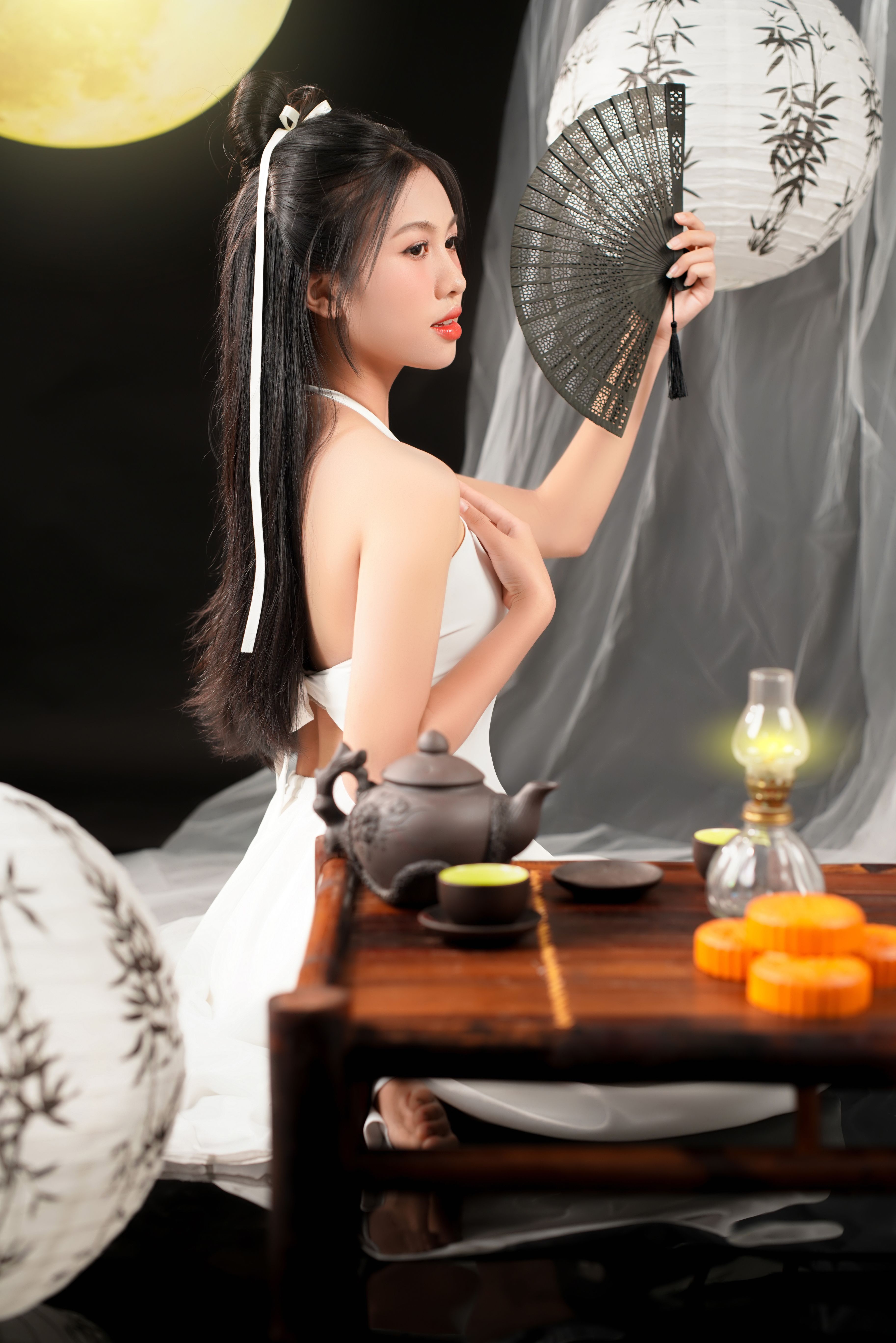 An elegant woman holding a traditional Chinese fan