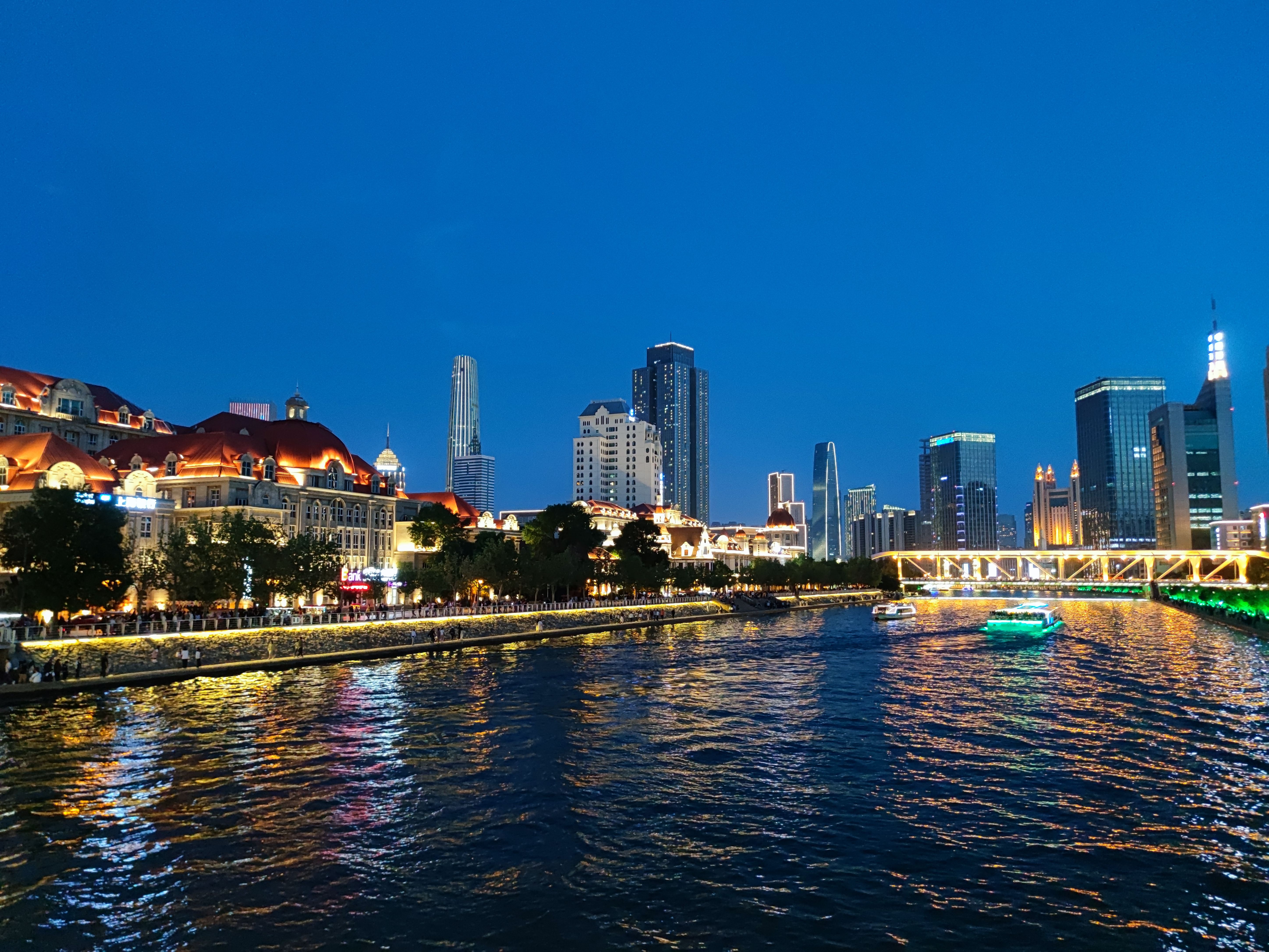 The lit skyline of Tianjin along the Haihe River at night